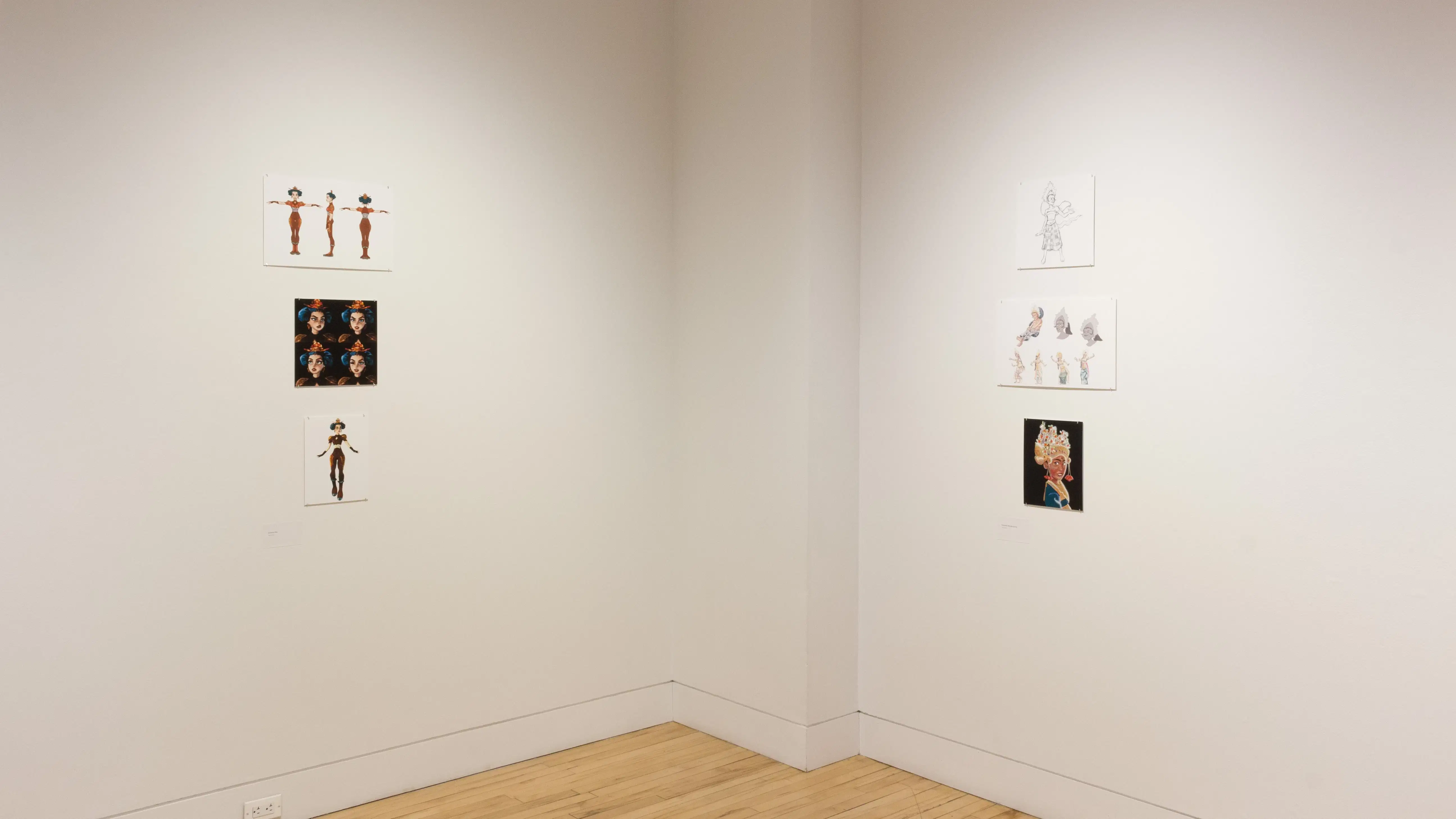  Angled view of two student works in the back corner of the gallery, showing printed mockups of animated characters.