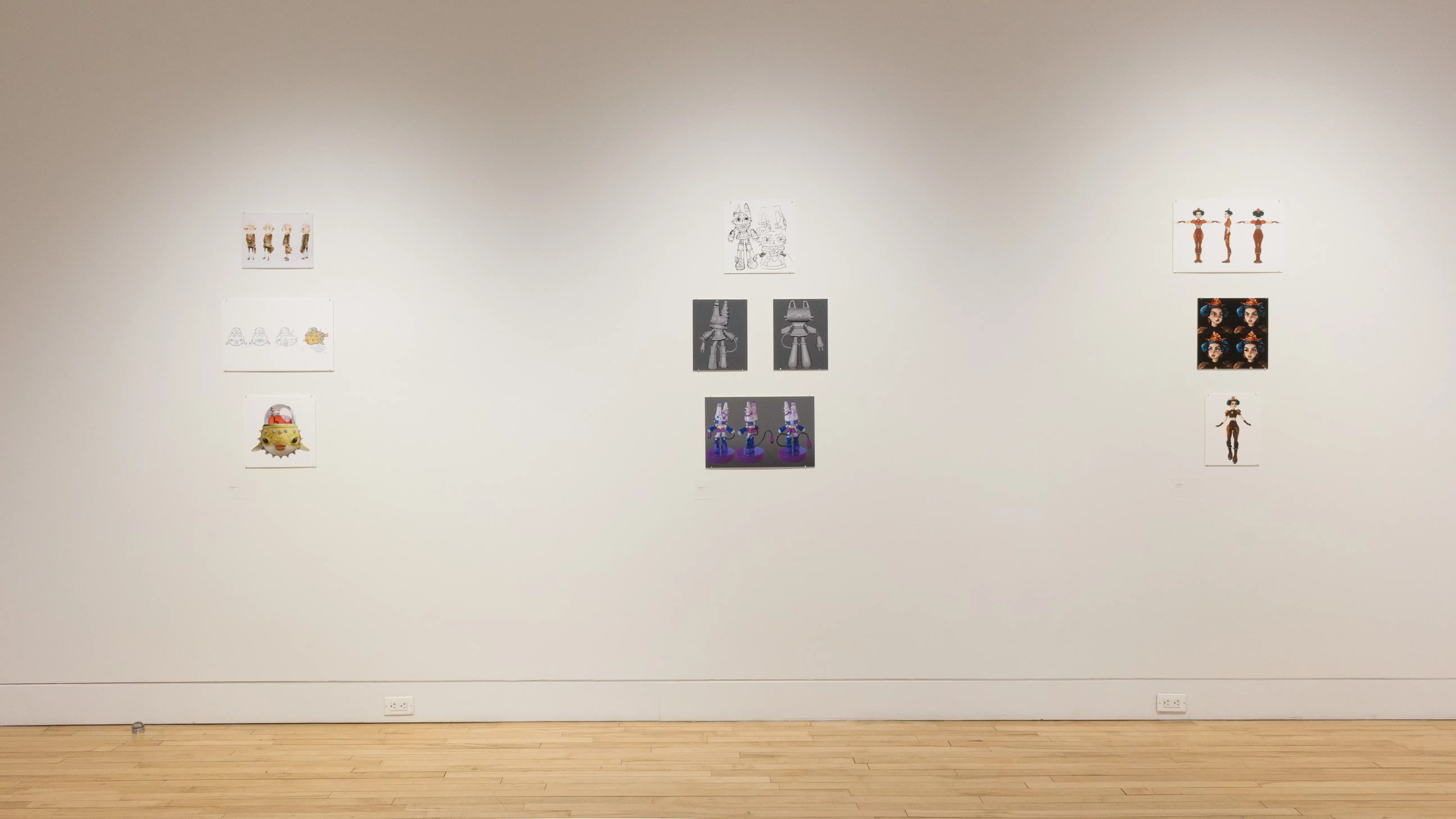 Closer front view of three student works, showing printed mockups of animated characters. 