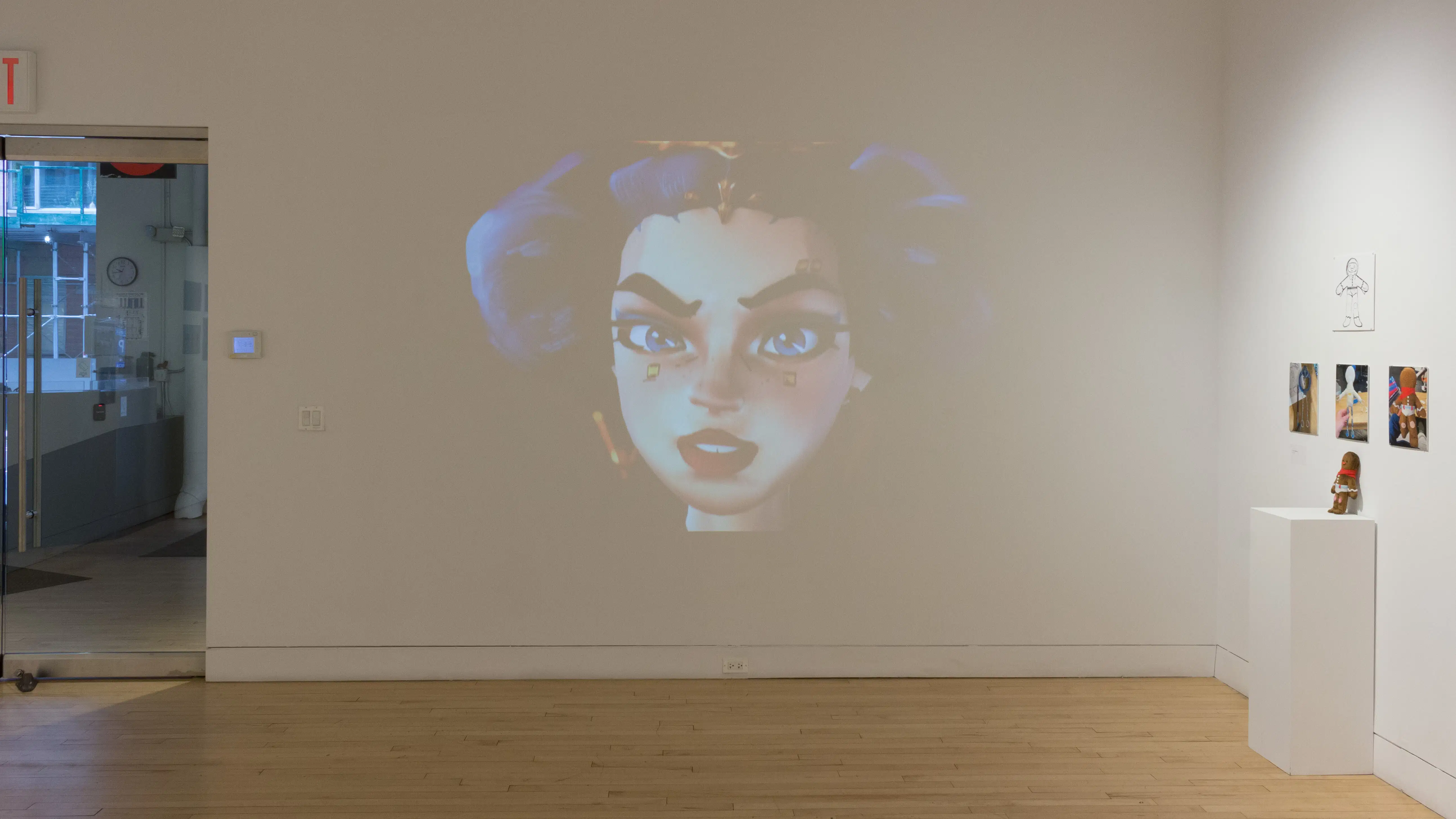 Front view of two student works, showing an animated projection, printed mockups of animated characters and a 3D character display on a pedestal. 