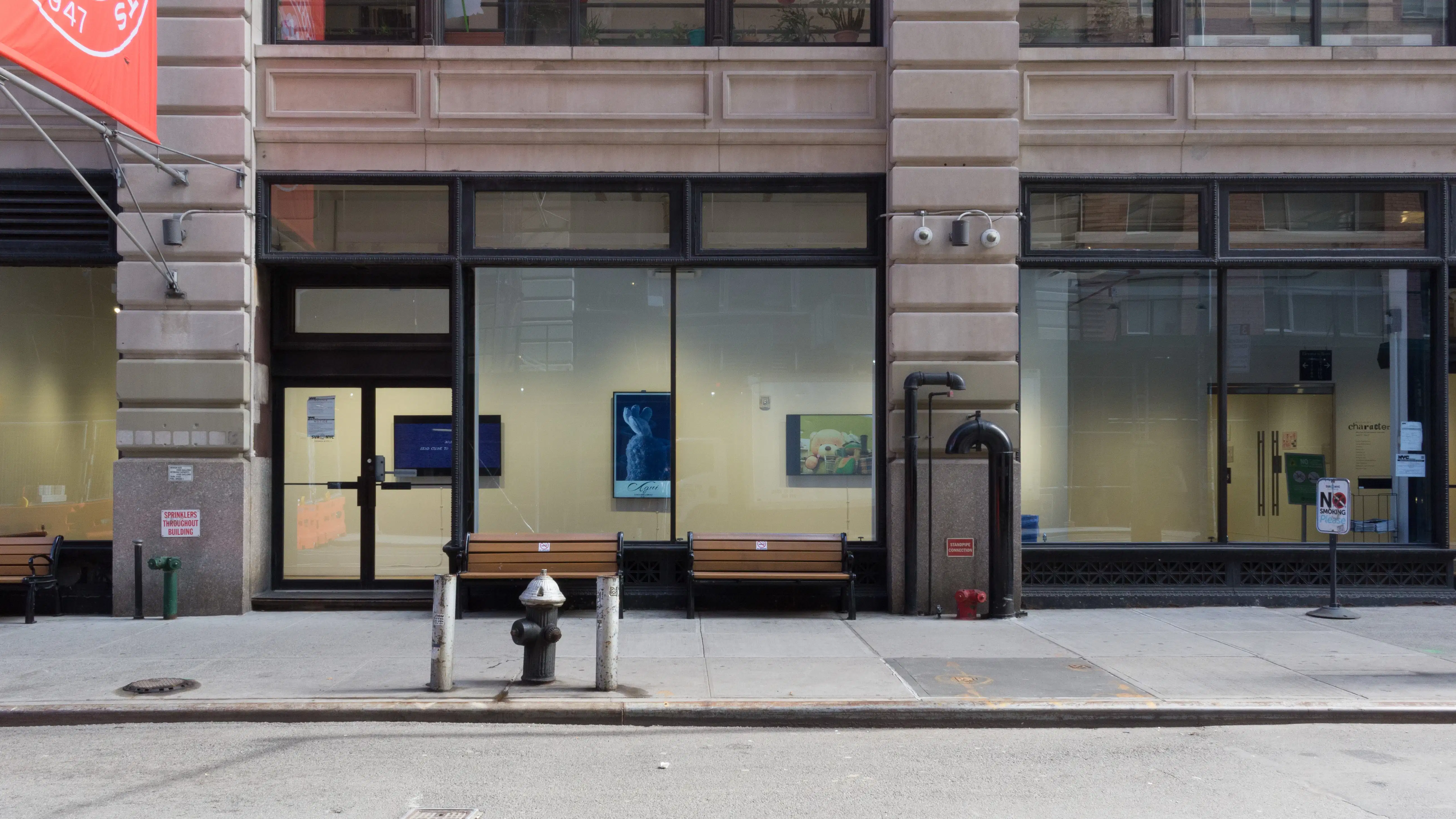 Street view of the SVA Flatiron Gallery space, with three monitors visible behind the glass windows.