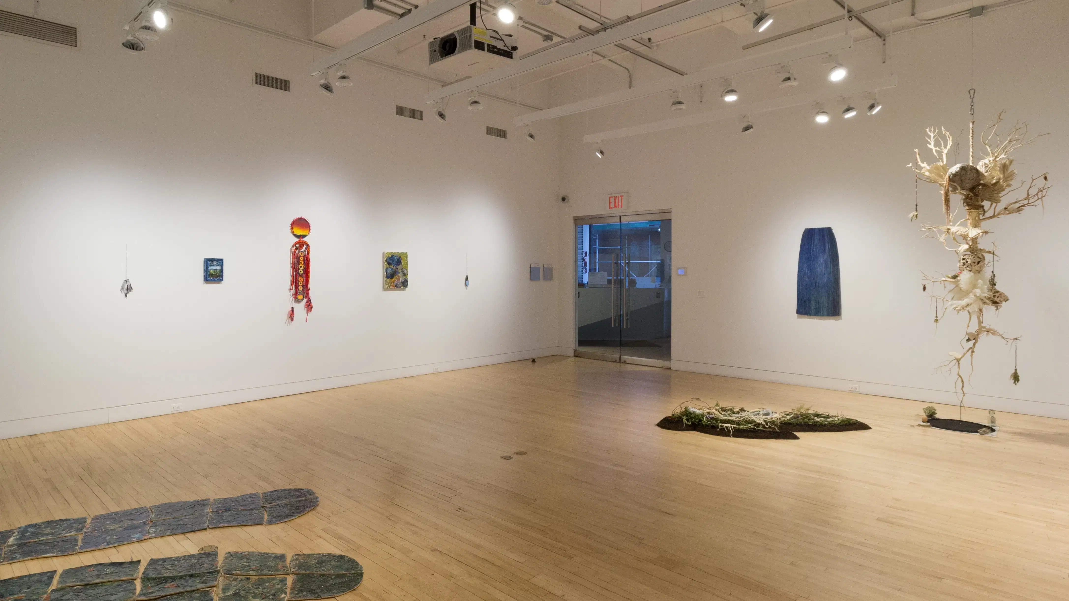 A back corner view of the SVA Flatiron Gallery shows works of various media, including sculpture, installations, and paintings. 