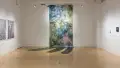 A view of the back wall in the SVA Flatiron Gallery, highlights a wall sized painting and installation piece that expands out onto the floor. 