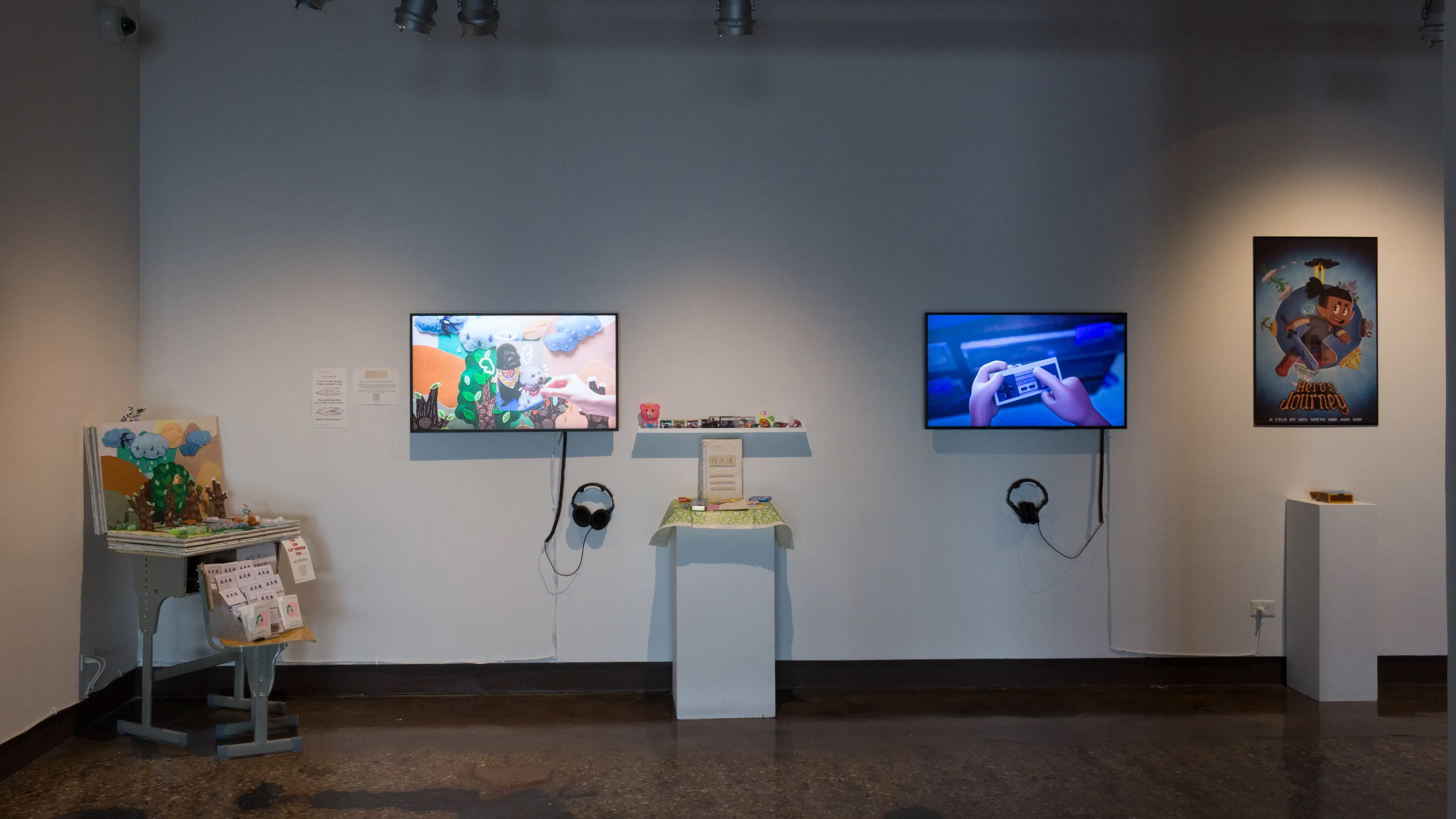 Installation image showing several sculptural installations interspersed between monitors playing animated reels.