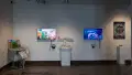 Installation image showing several sculptural installations interspersed between monitors playing animated reels.