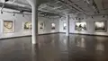 An empty art gallery with tall ceilings and natural light.