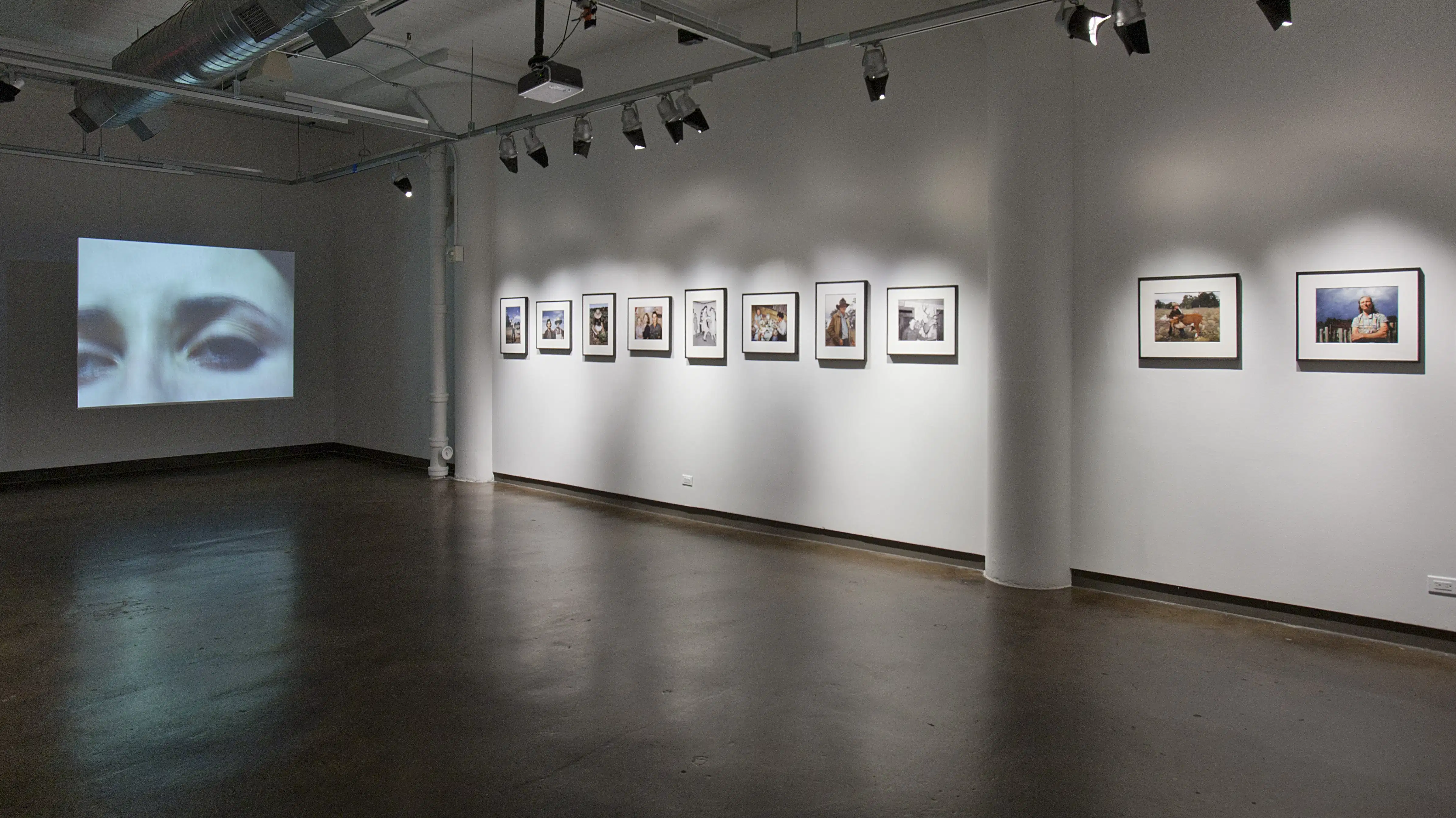 A gallery with one video art piece of a woman looking distressed.