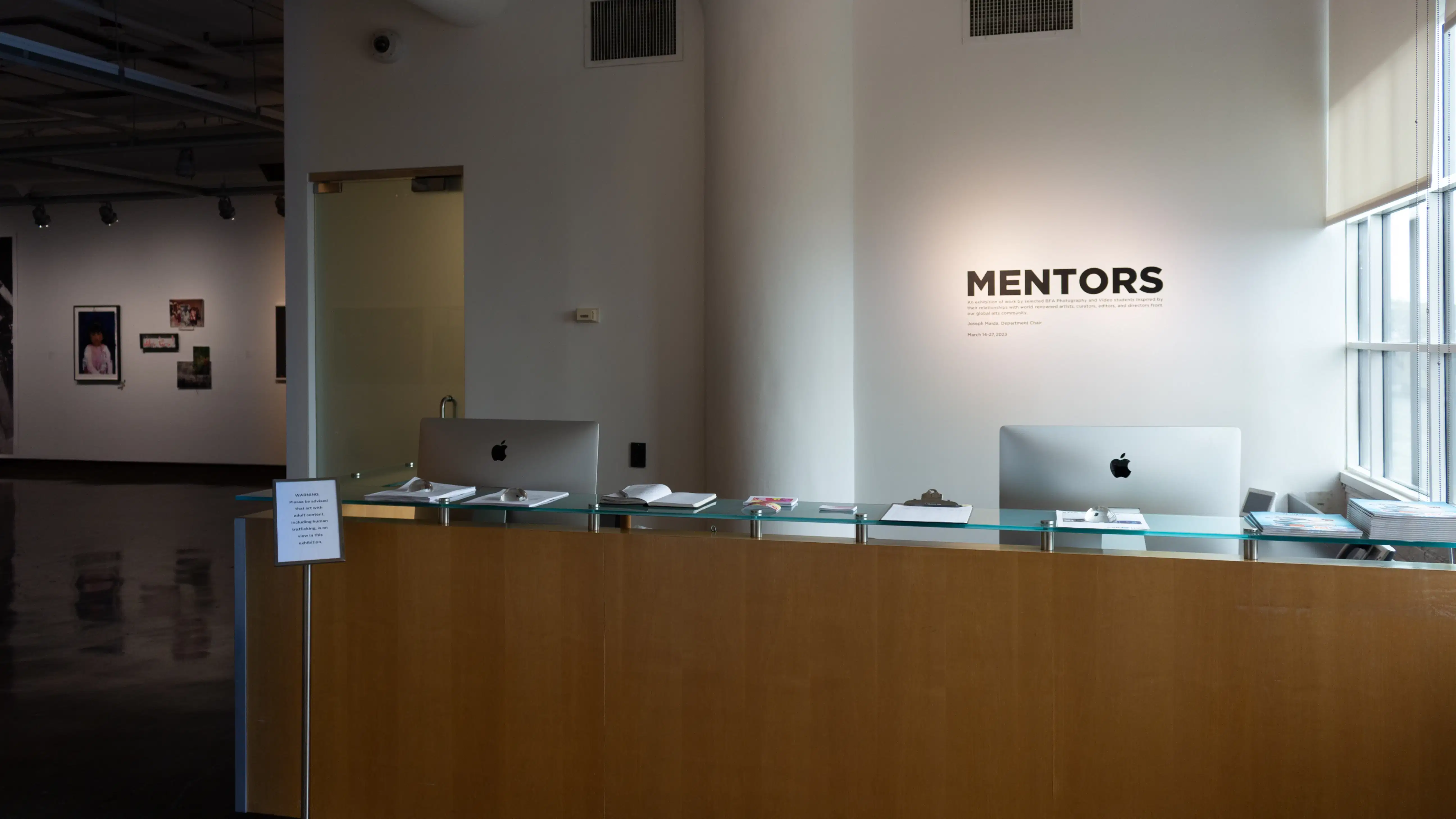 Installation image showing desk with "MENTORS" in vinyl on the wall.