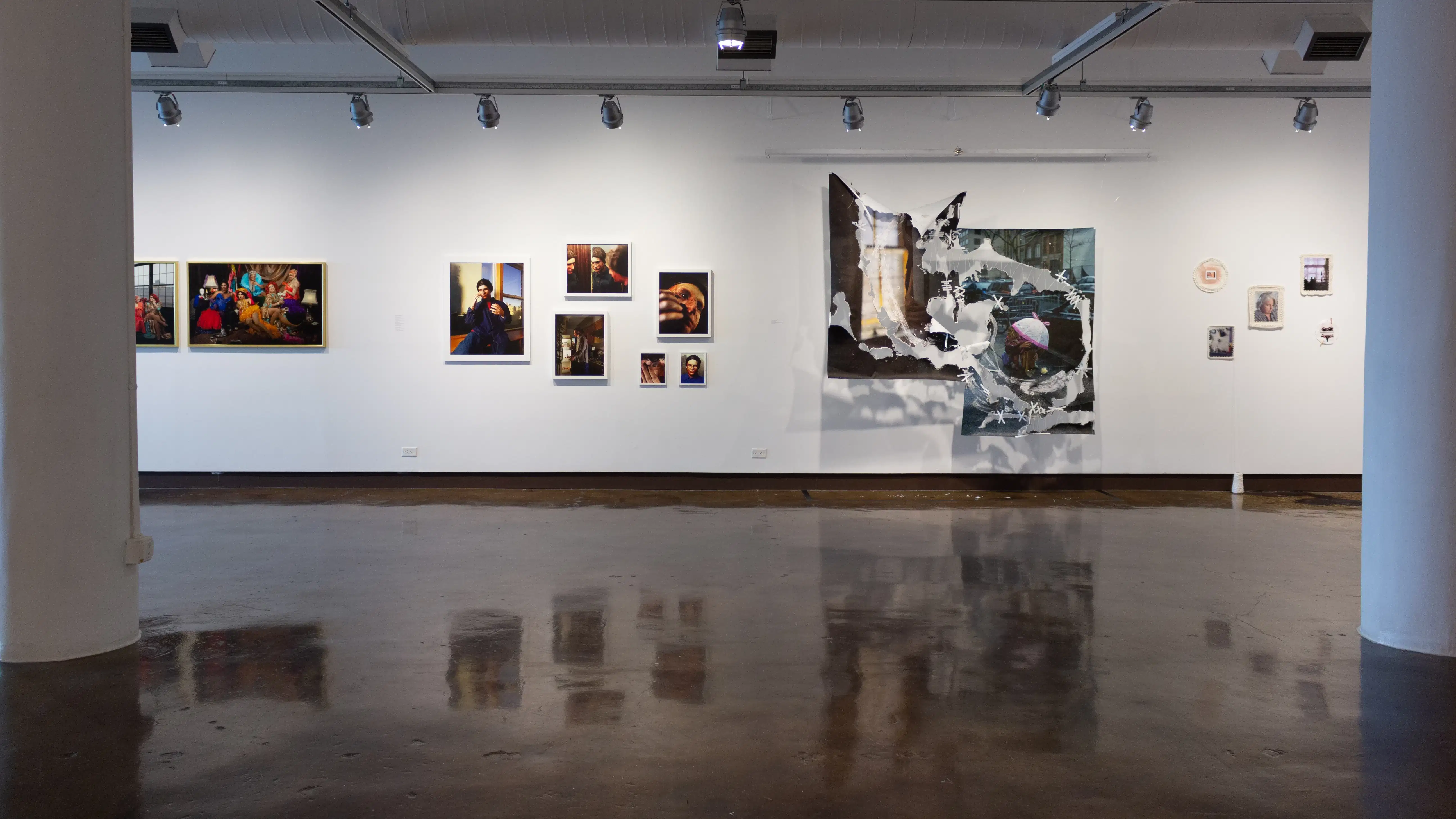 Installation image featuring 13 framed photographs and a hanging photo installation.