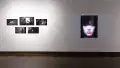 Installation image showing 5 black and white photos on the left and a large portrait on the right.