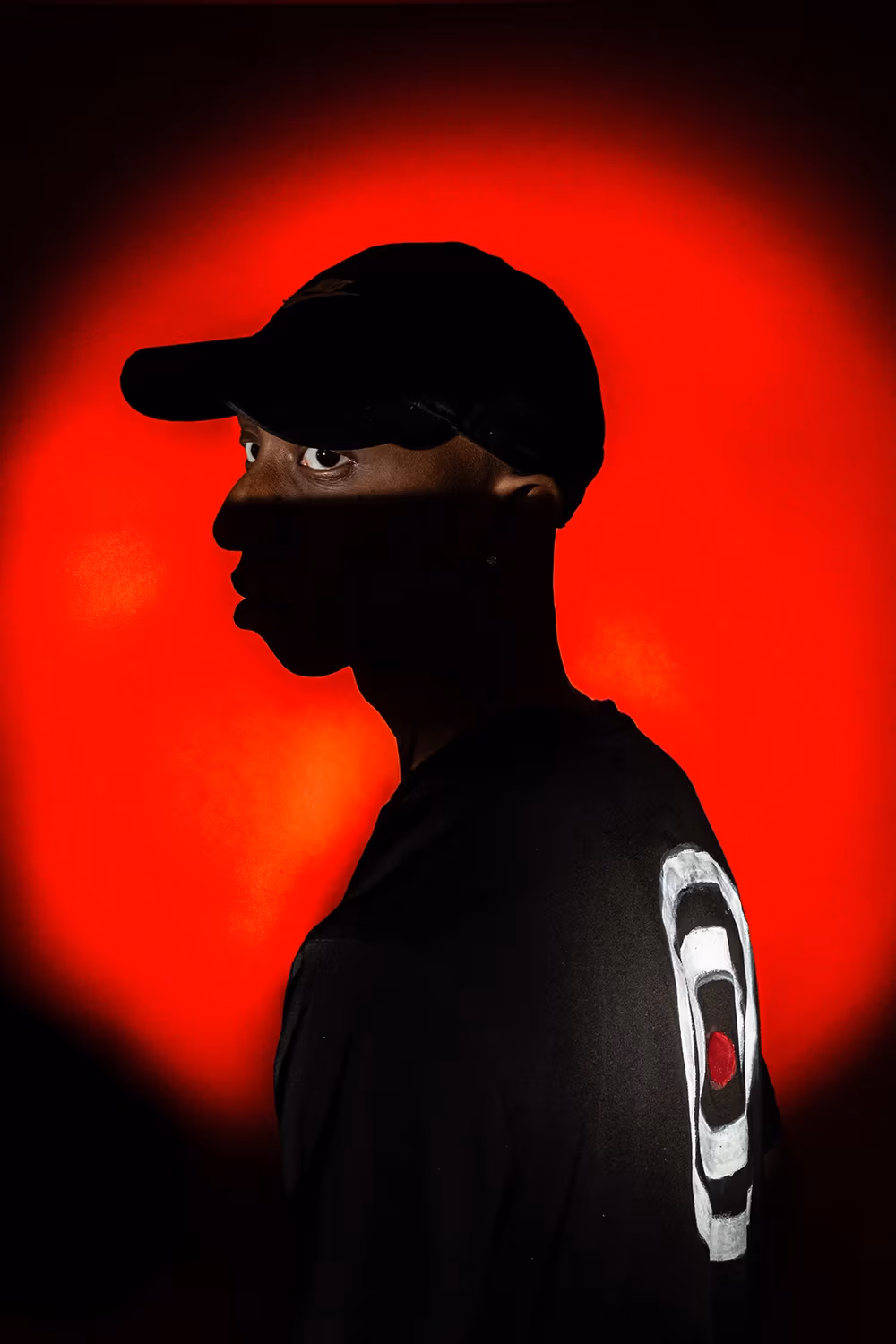 Red backlit circular background, partially silhouetted man with a target on his back