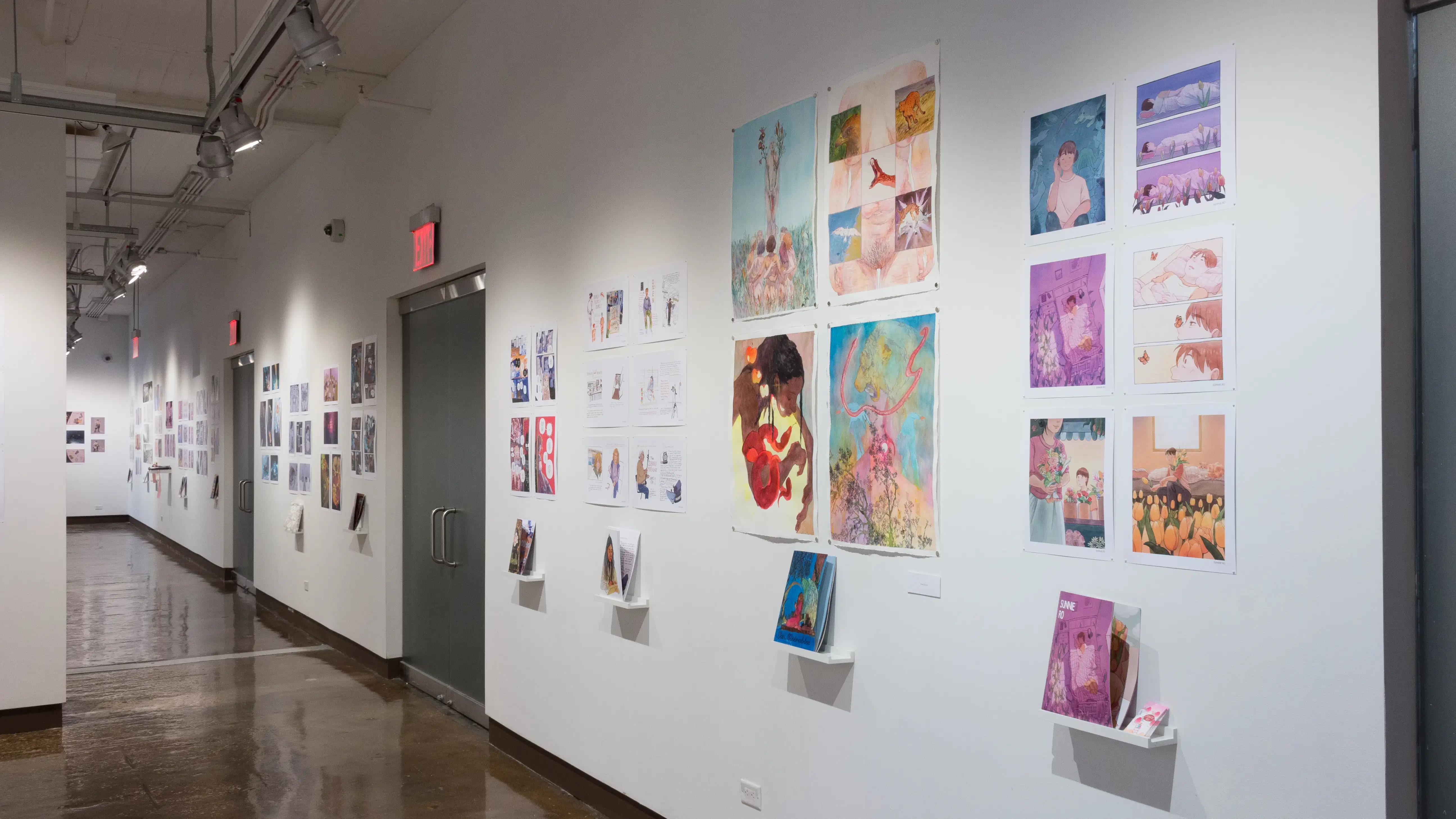 The prints hanging on the walls vary in dimension, style, and color. Books sit on shelves beneath the prints.