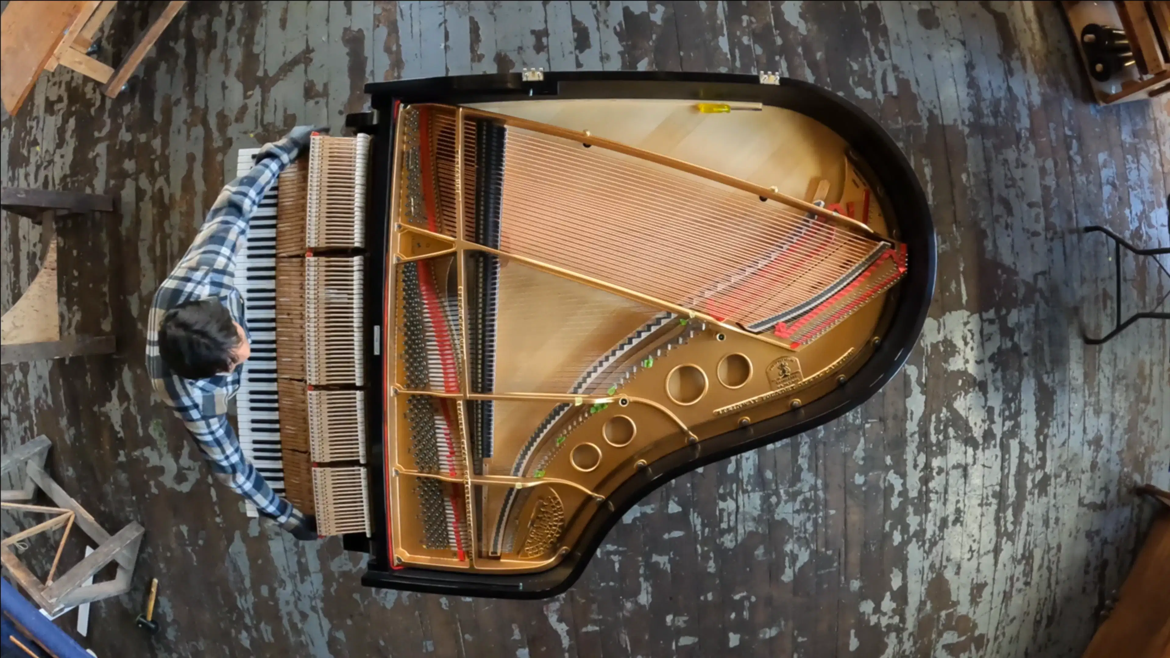 Overhead view of the piano halfway through production with a pianoman. 