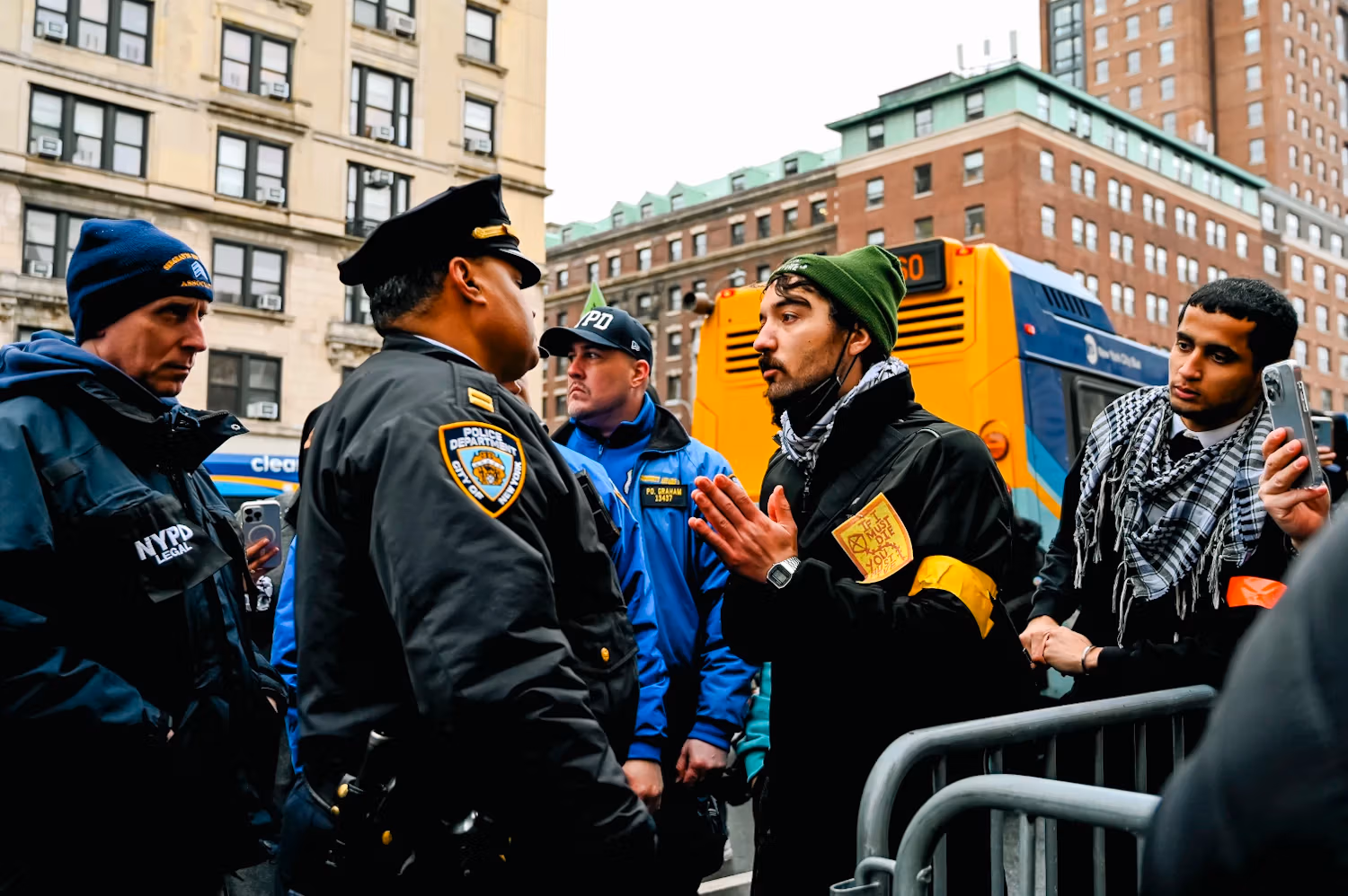 Facing the NYPDs, the green hat man is making a request.