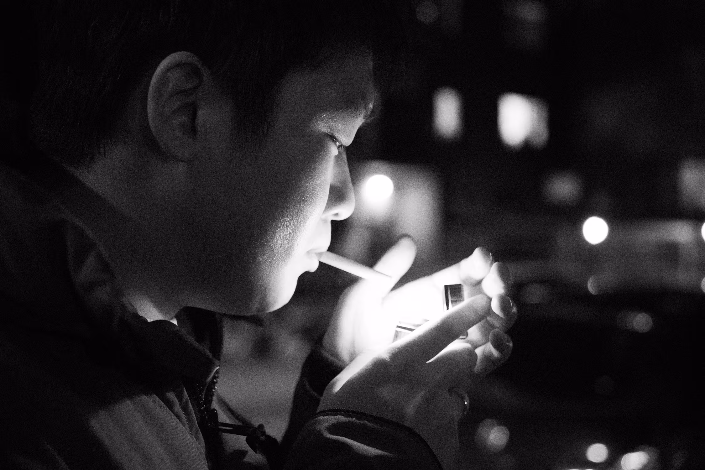 In the cold and windy winter, a man lights a cigarette