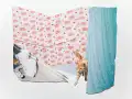 Color photograph of an installation shot from Xunzhen Zhu’s photographic 3D collages series “House Hold”. A collaged domestic scene combined photographs of blue curtain, pink floral bed sheets, window sill and a cat.  				