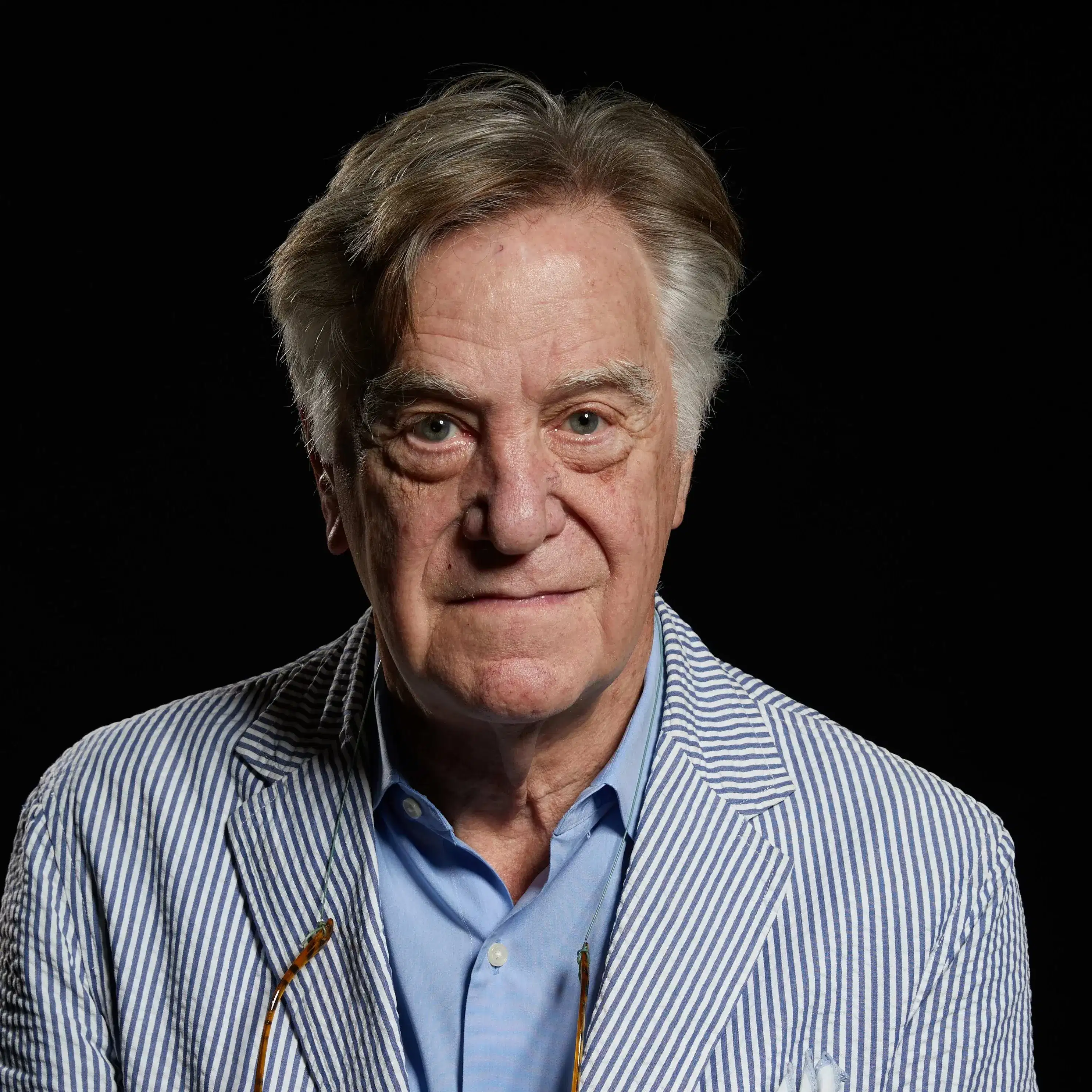 Man in a striped suit posing for a portrait.