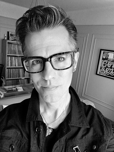 Faculty member Joe Newton wearing black rimmed glasses and a black shirt.