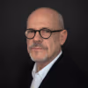 Man with glasses poses for a portrait.