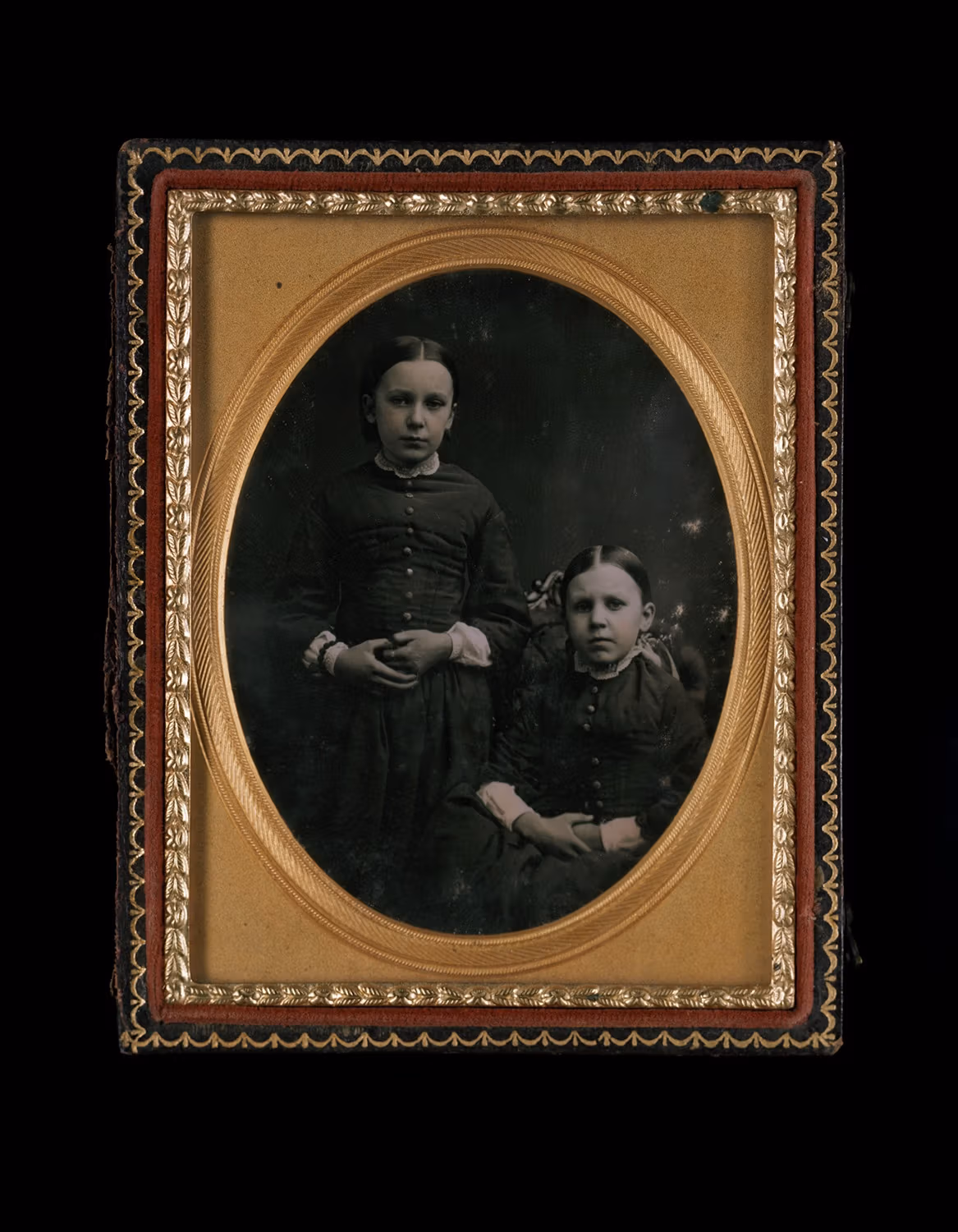 A photo of a framed daguerrotype featuring two young girls