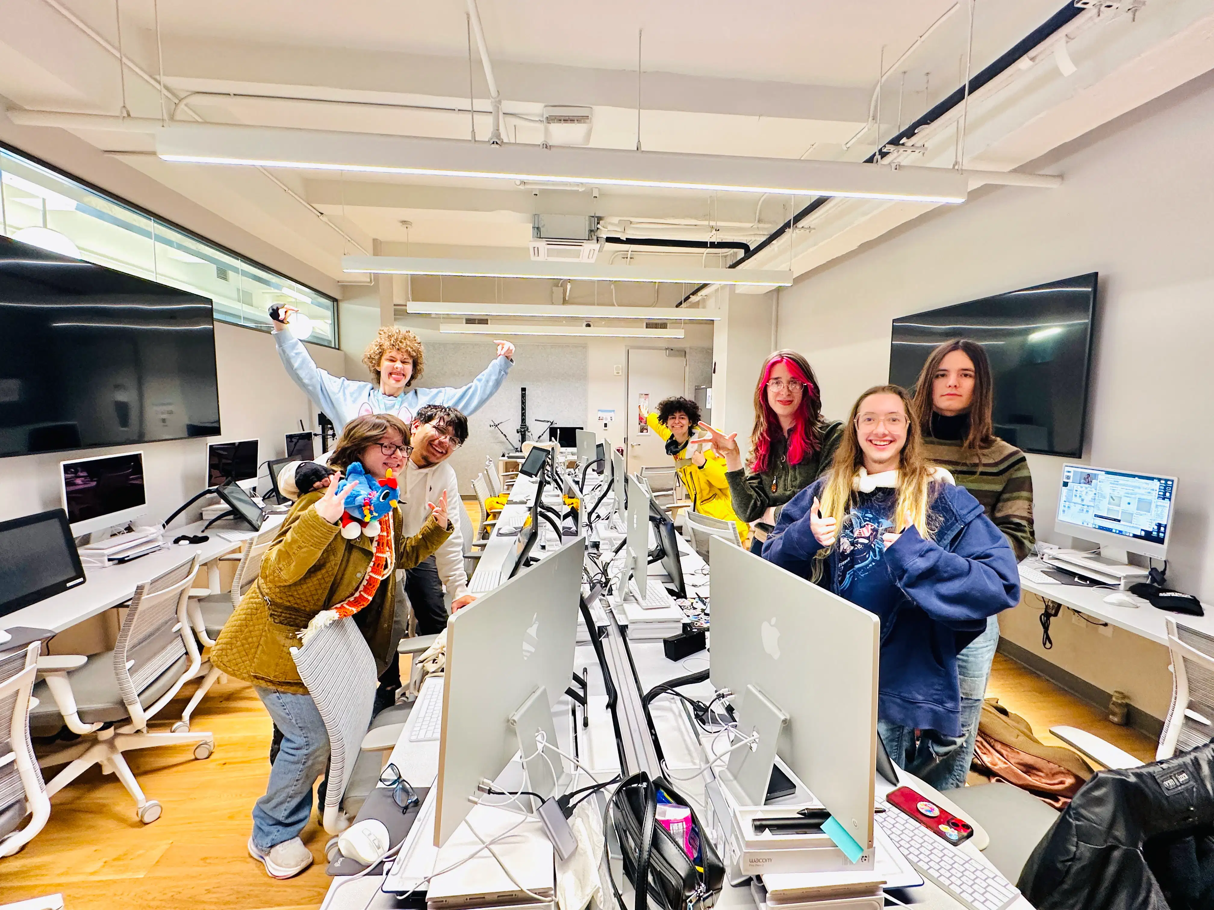 Students gather for a group photo in a computer lab classroom. 