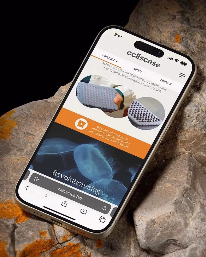  A smartphone rests on a rock, displaying its screen in a natural outdoor setting.