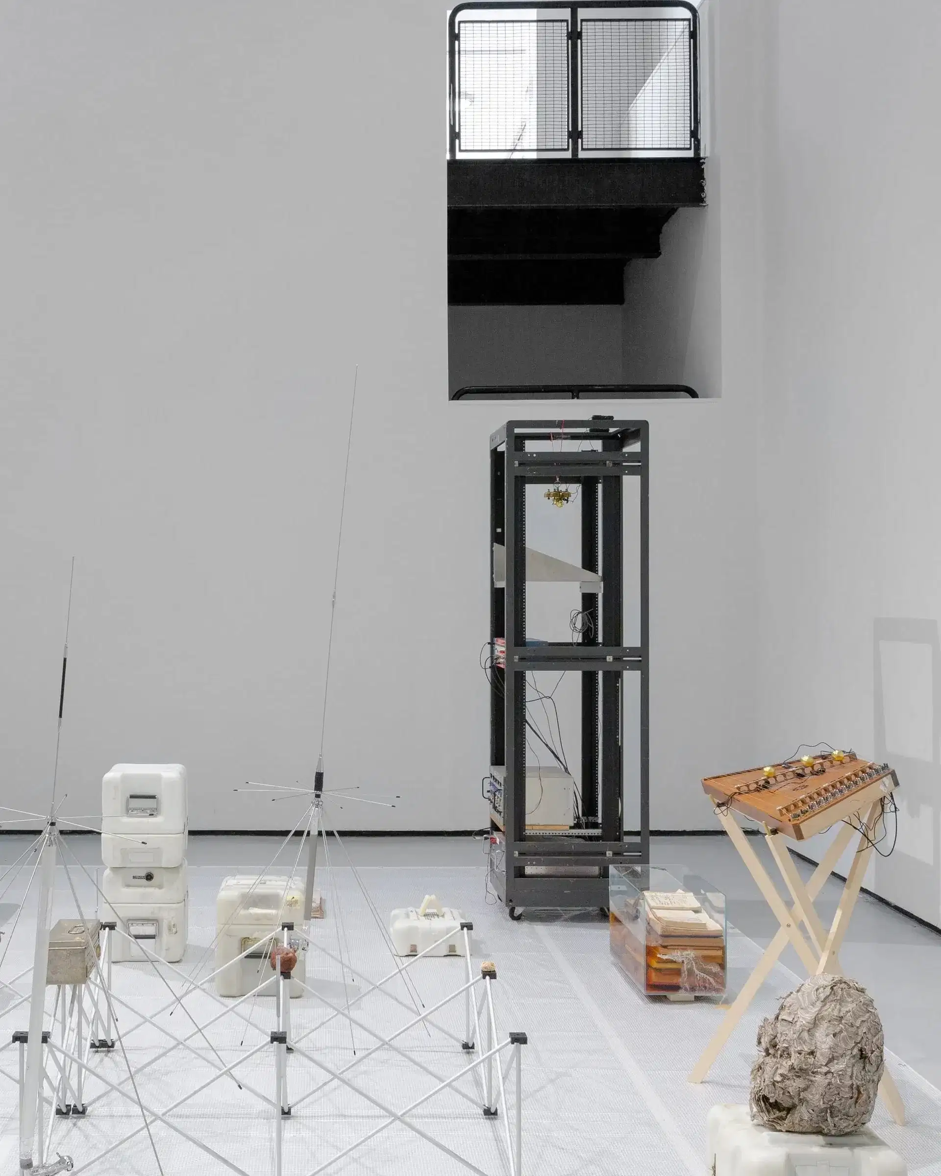 Installation by Stephen Lordan. The image shows various objects laid out on the floor in light grey room.