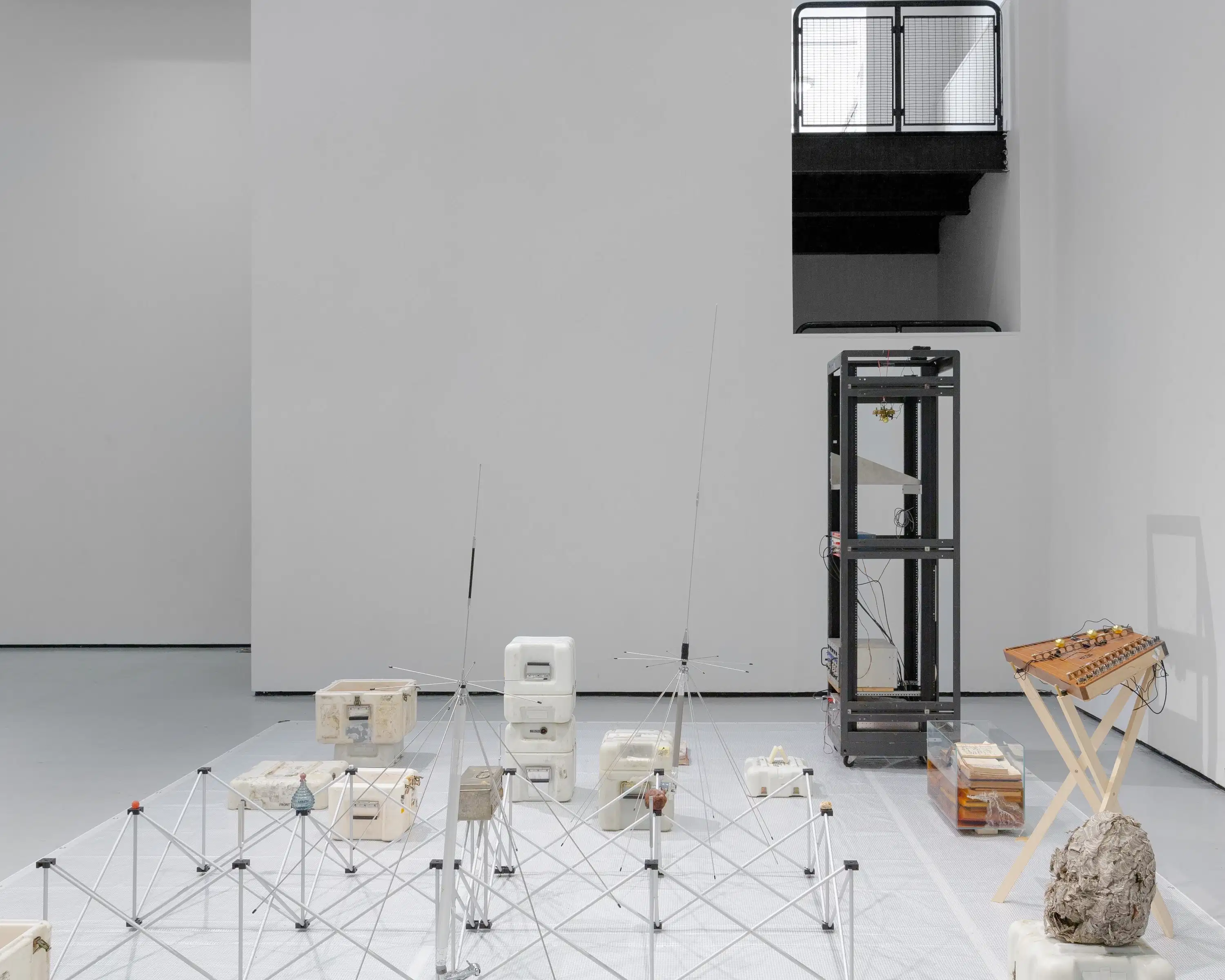 Installation by Stephen Lordan. The image shows various objects laid out on the floor in light grey room.