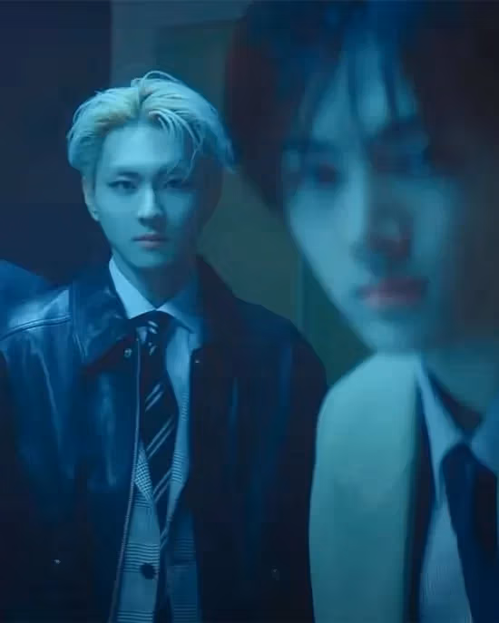 Two male kpop idols look at the viewer with a blue tone over the image.