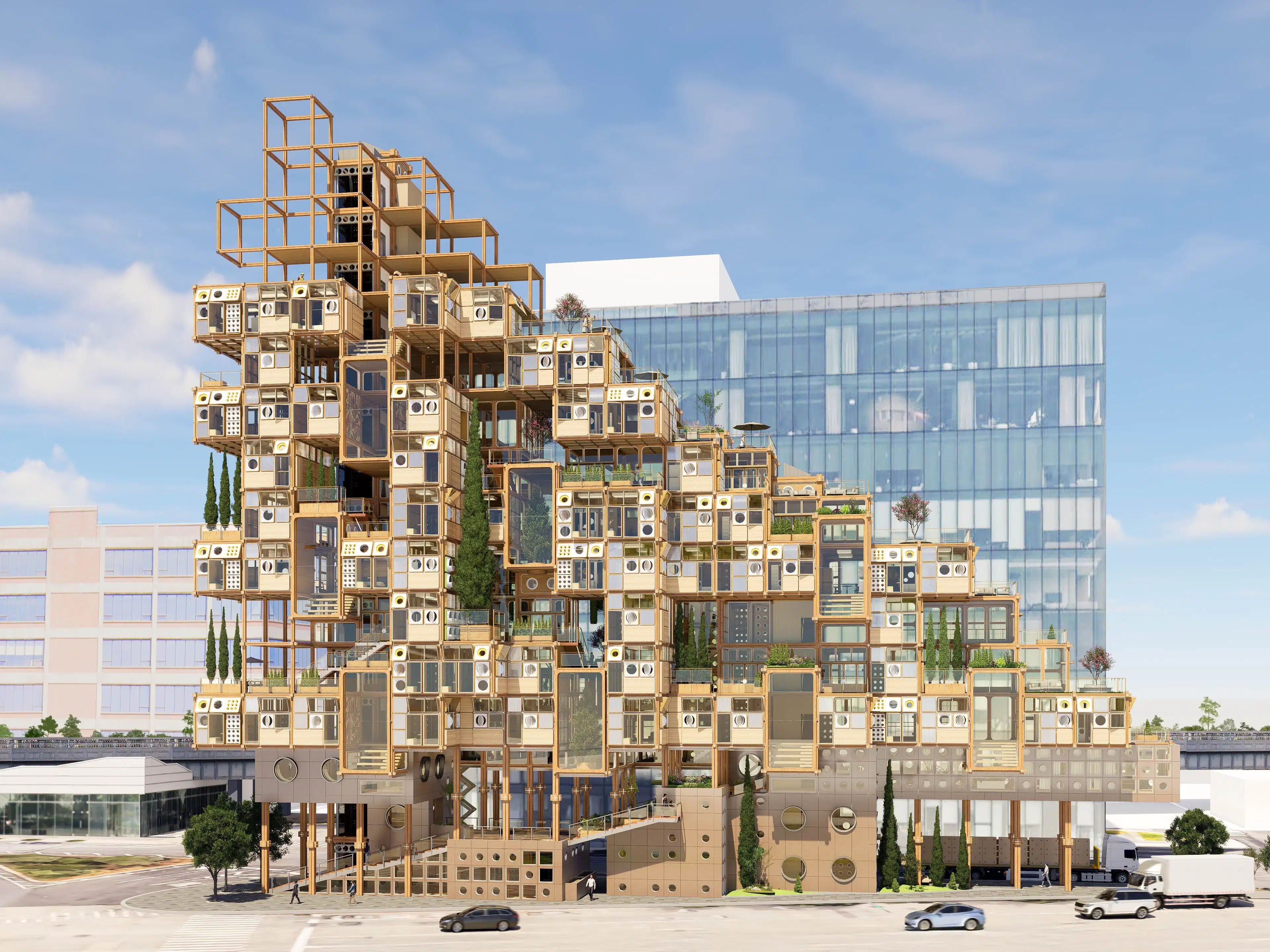 A modular building with a grid of square and circular windows, surrounded by trees. The structure is light brown, giving a modern, geometric feel.