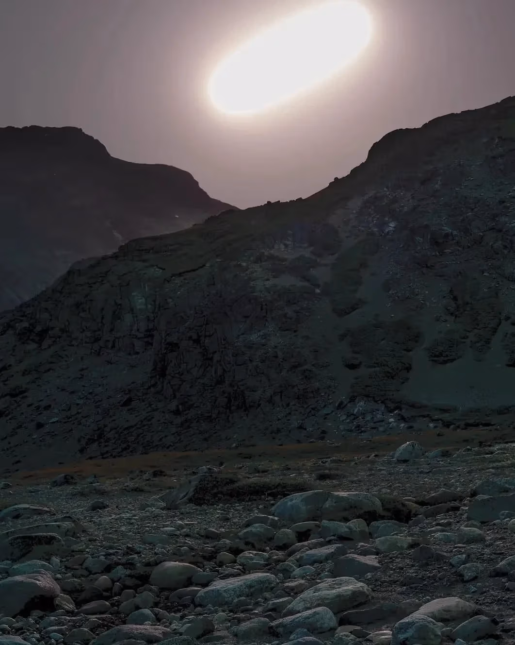  Horizontal photograph of night landscape with moon in sky.