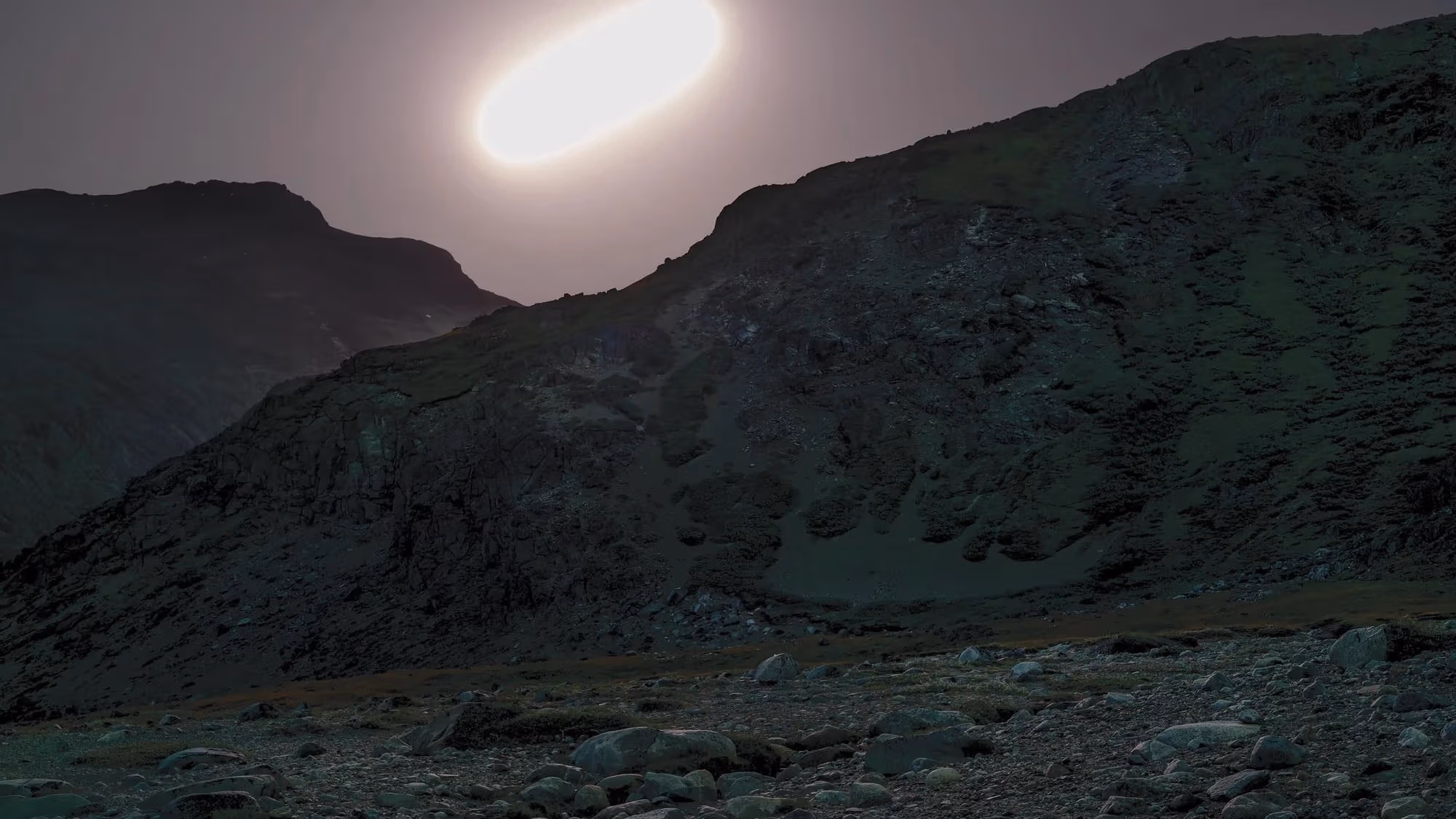  Horizontal photograph of night landscape with moon in sky.