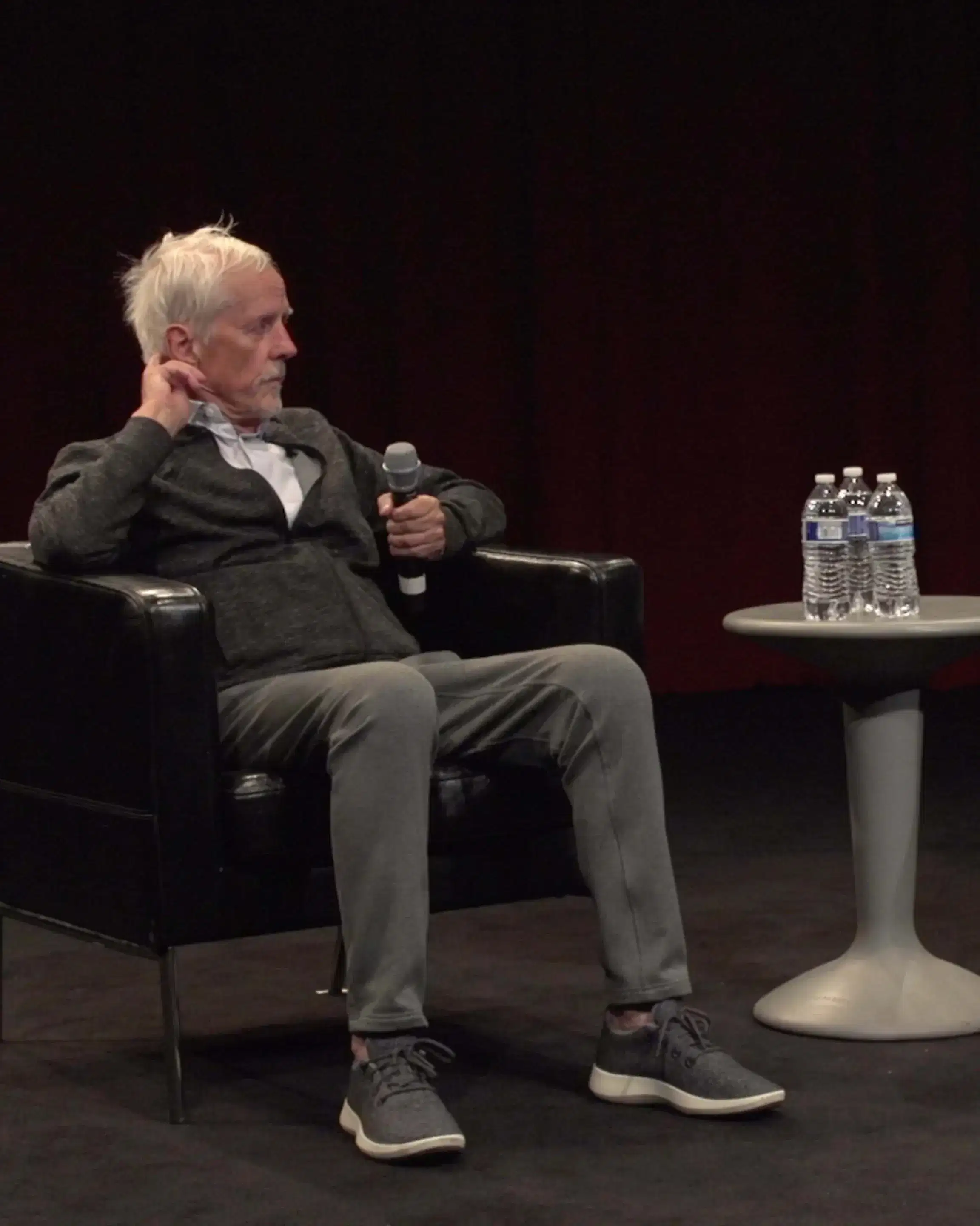 Two people sitting on stage talking.