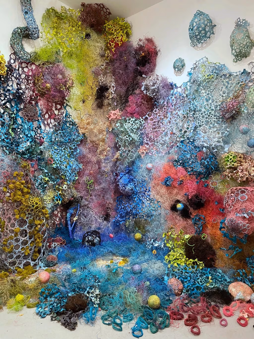 Mixed media, including cotton-covered wire, acrylic, maps, clay, paper, encaustic, styrofoam, moss, branches, found toys, ceramics, and debris