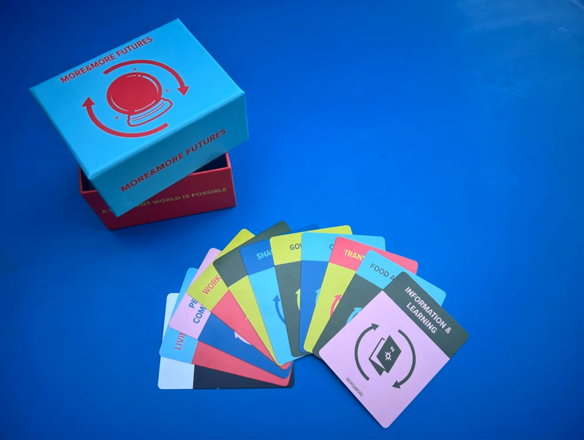 A hand of cards fanned out on top of a blue background. An open box is on the top left.