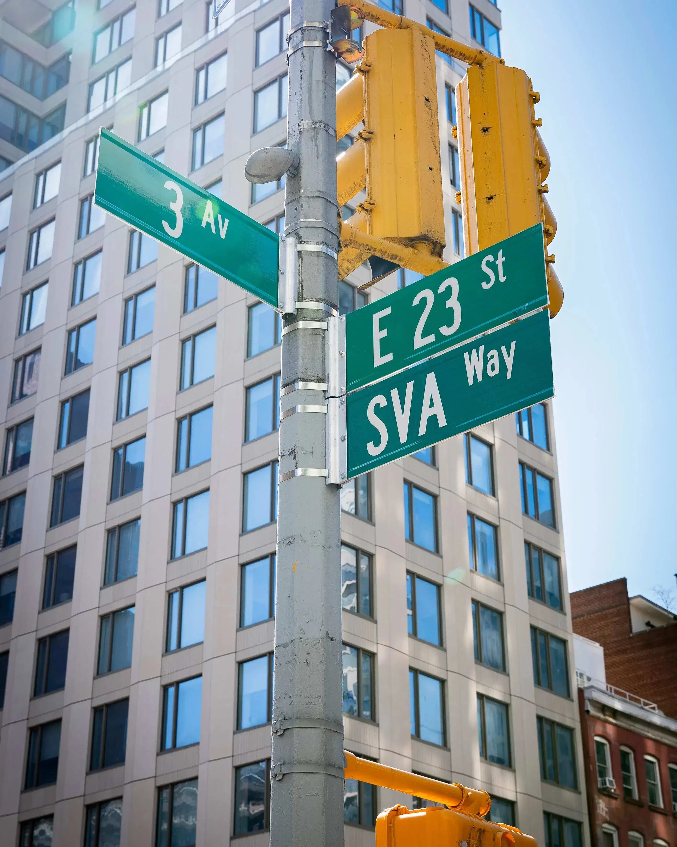 Street sign showing the corner of 3rd Avenue and 23rd Street; under the 23rd street sign is a duplicate sign that reads "SVA Way"