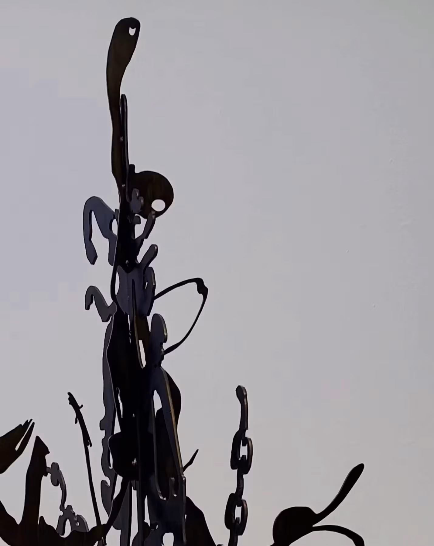 A black metal abstract sculpture against a gray background