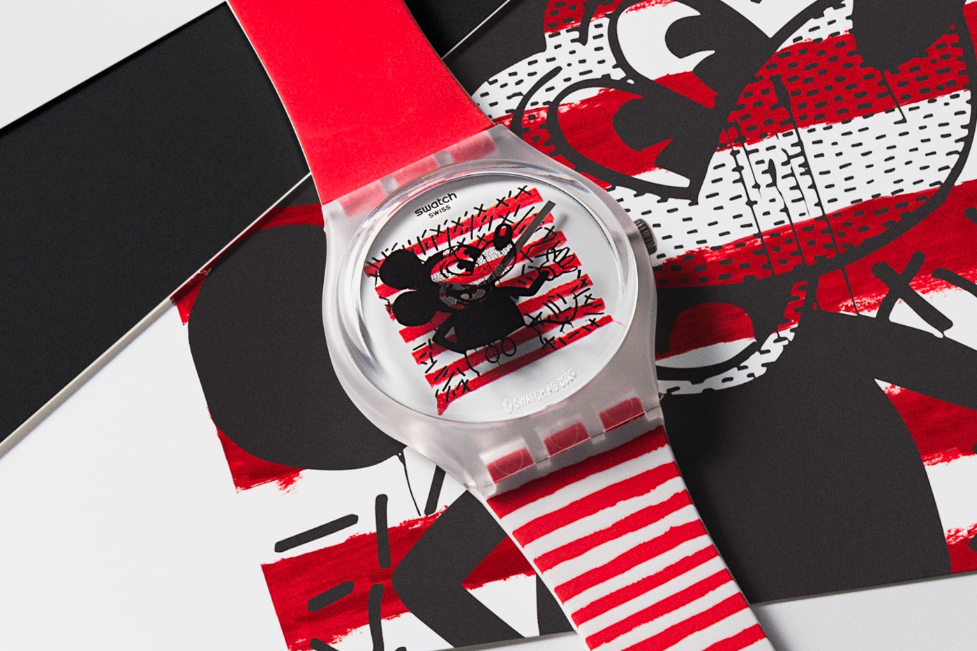 A photograph of a red, white and black wristwatch with a Keith Haring illustration of Mickey Mouse on its face.