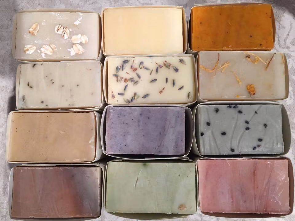 A photograph of 12 bars of differently colored and textured soaps.