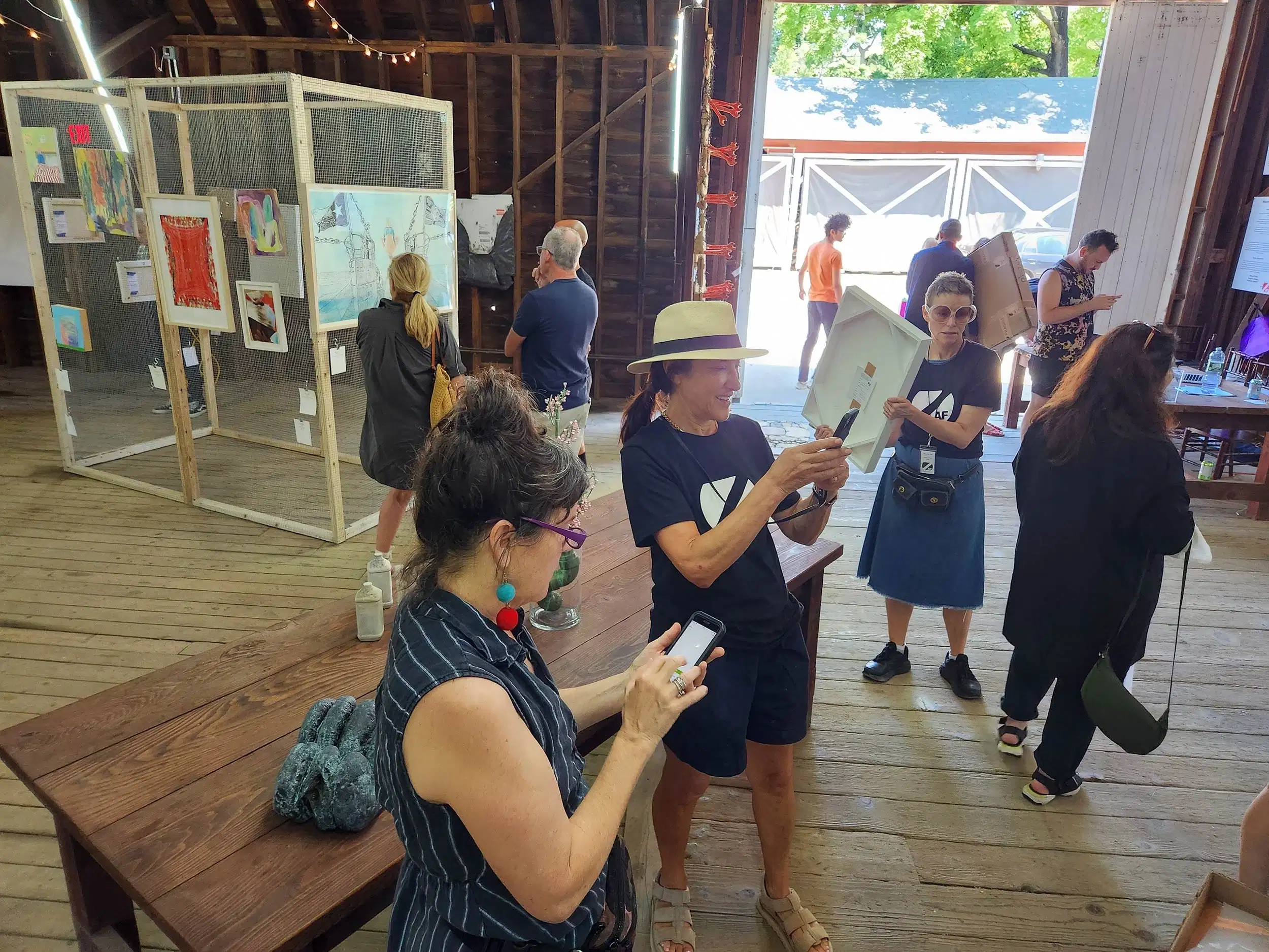 A group of people gathered around a table, with one person holding a paper and others discussing documents.