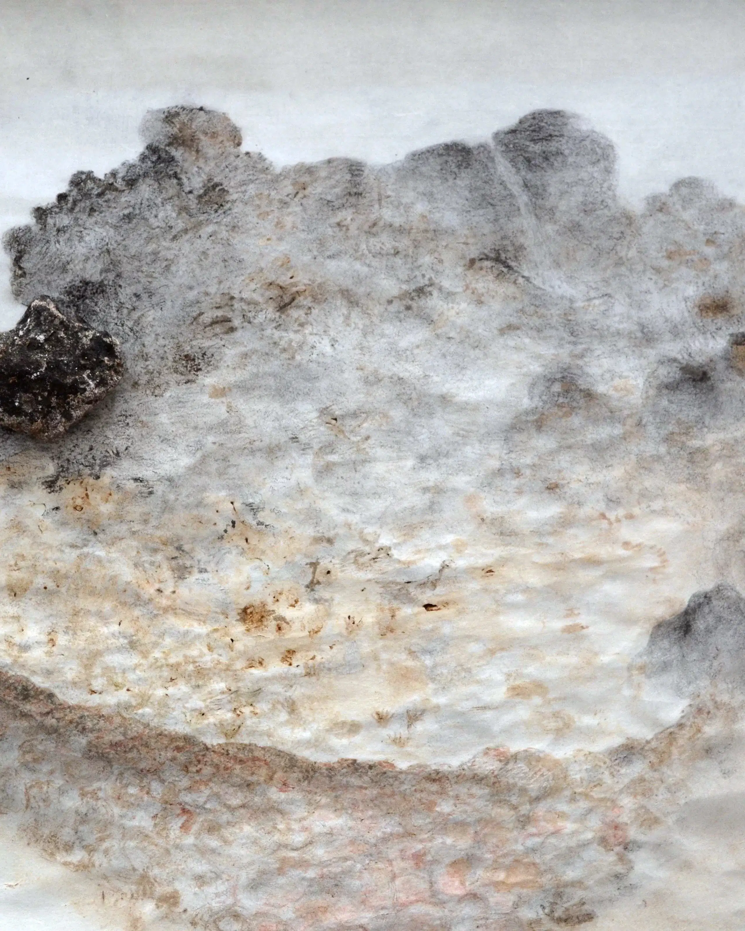 Macro shot of a fuzz type material with black soot on it over a white background.