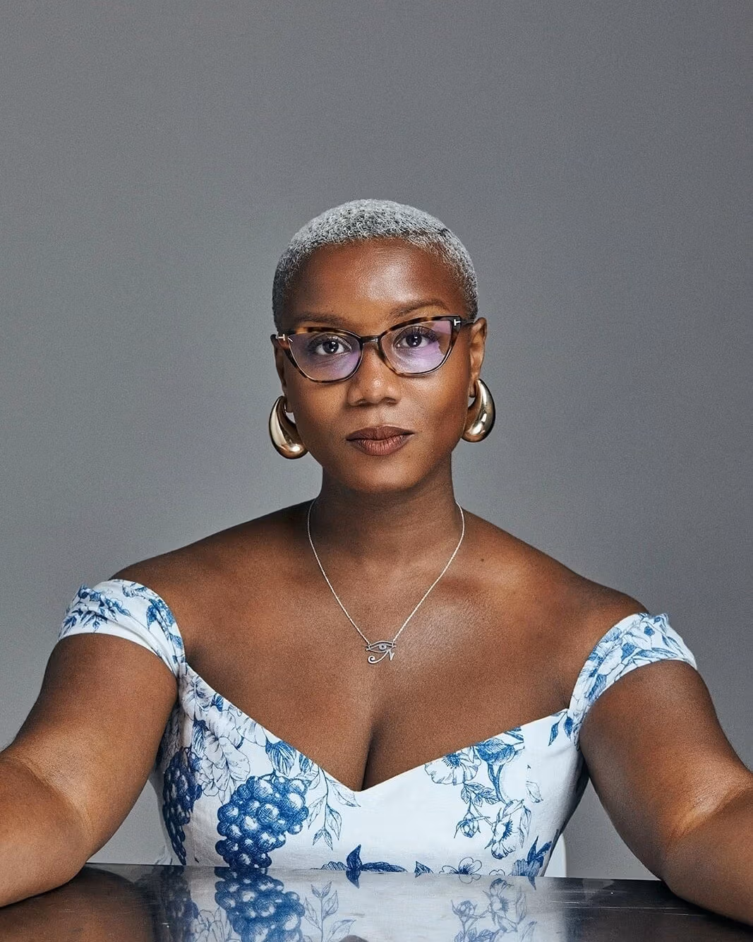 Portrait of a woman, Ja'Tovia Gary, posing in front of a reflective table. 