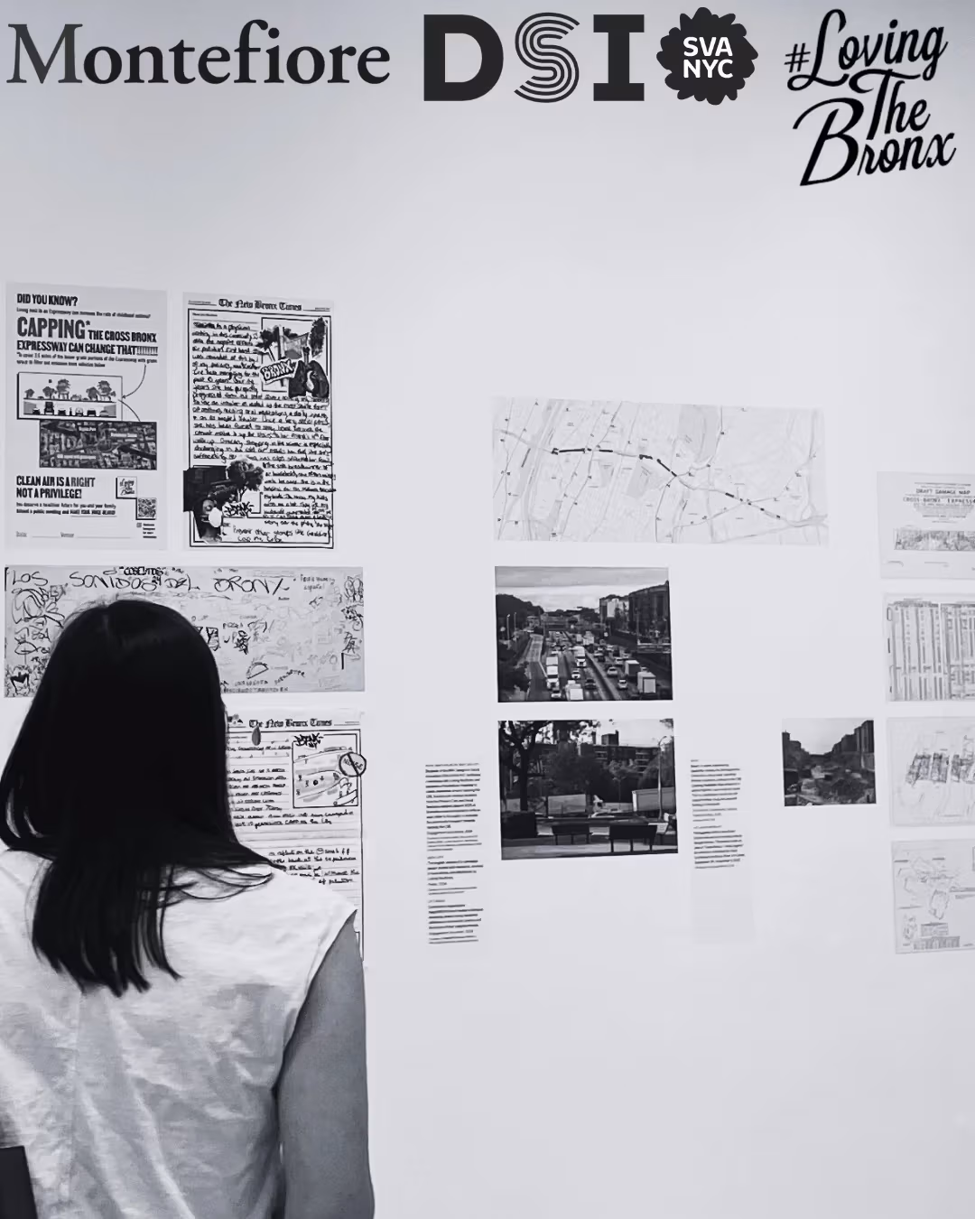 Black and white photo in art gallery with multiple pieces of work on wall and 2 silhouettes on the left side looking at the work. Logos of Montefiore, SVA DSI, #Loving the Bronx, in top right