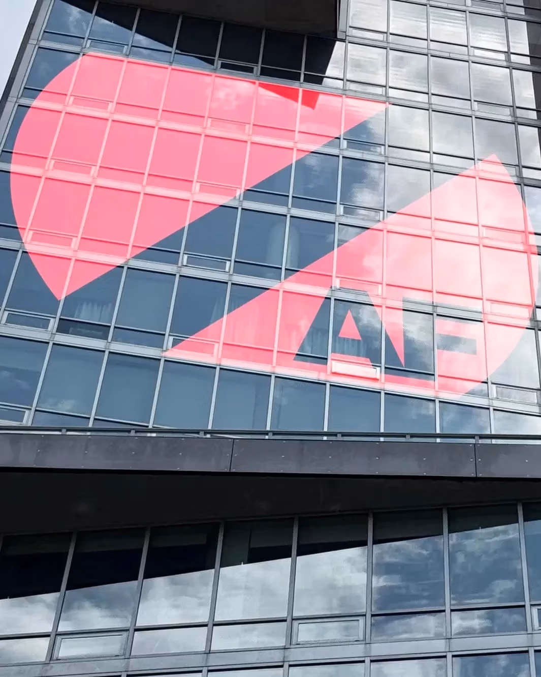 A modern skyscraper facade with the Zero Art Fair logo displayed in its windows.
